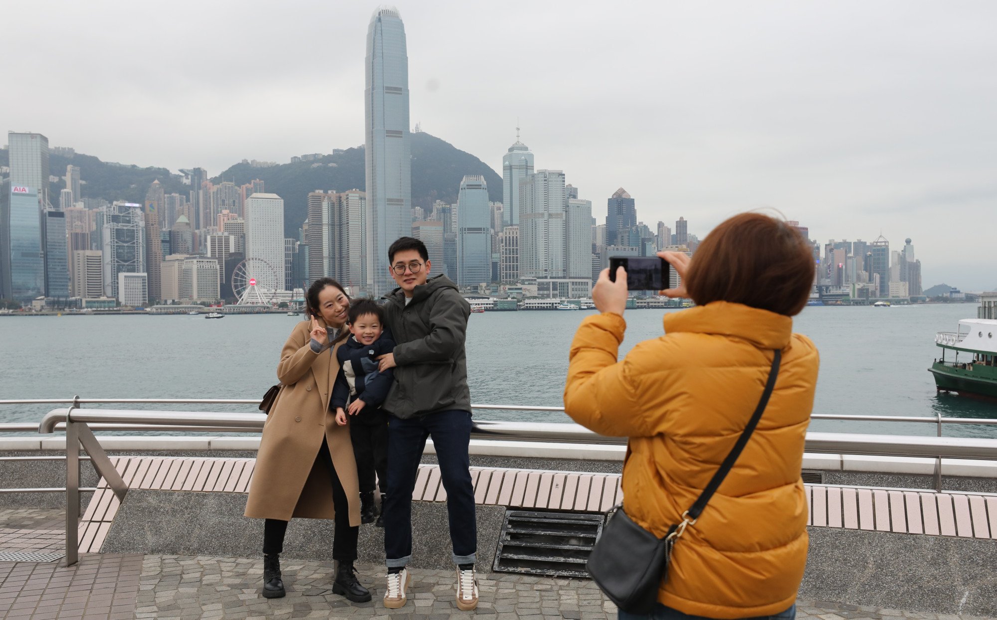 Tourists from mainland China pose for pictures at Tsim Sha Tsui’s Victoria Harbour waterfront. Photo: Xiaomei Chen