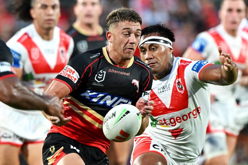 A man passes the ball during a rugby league match