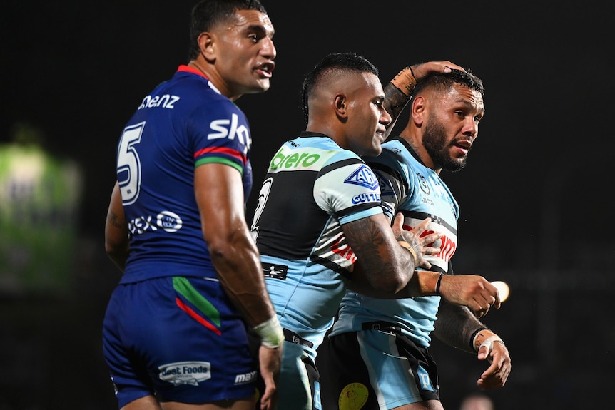 A team of rugby league player celebrate scoring a try