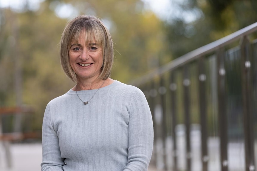 a woman with short hair smiles at camera