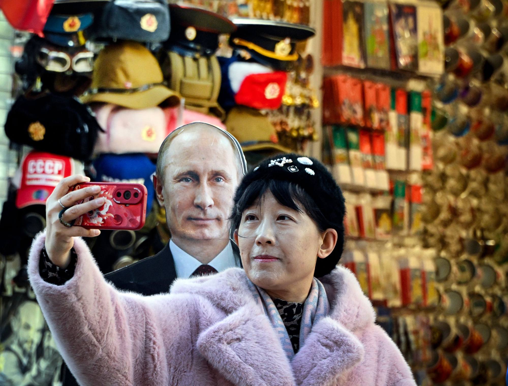 A tourist takes a photo with a cardboard image depicting Russian President and presidential candidate Vladimir Putin in downtown Moscow on Monday. Photo: AFP