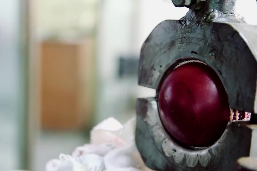 The cricket ball is placed between two metal arcs and pressed