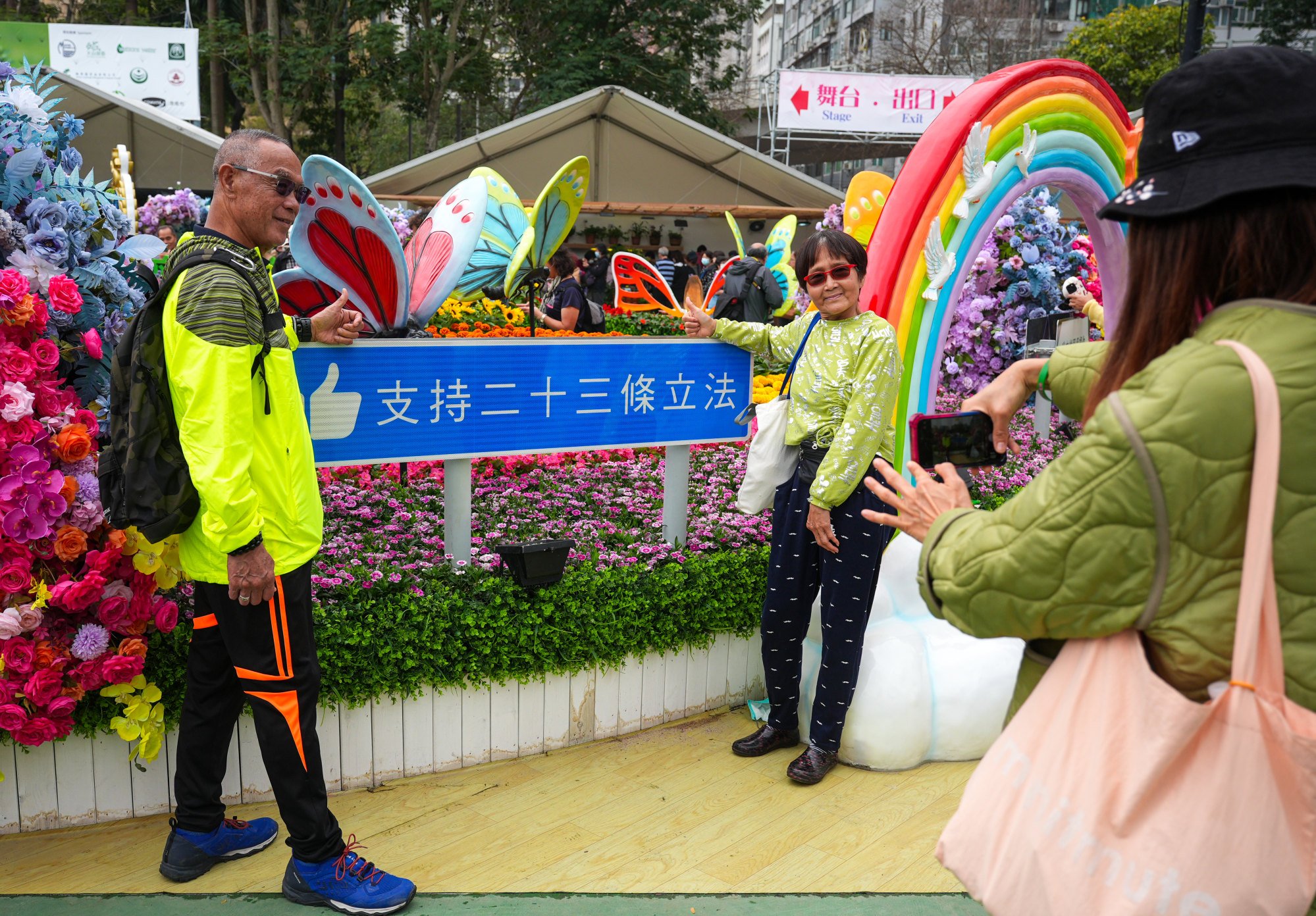 Visitors take selfies in front of a sign supporting the Article 23 bill at a flower show in Causeway Bay. The fast-tracking of the bill was a bombshell for many in the establishment. Photo: Eugene Lee