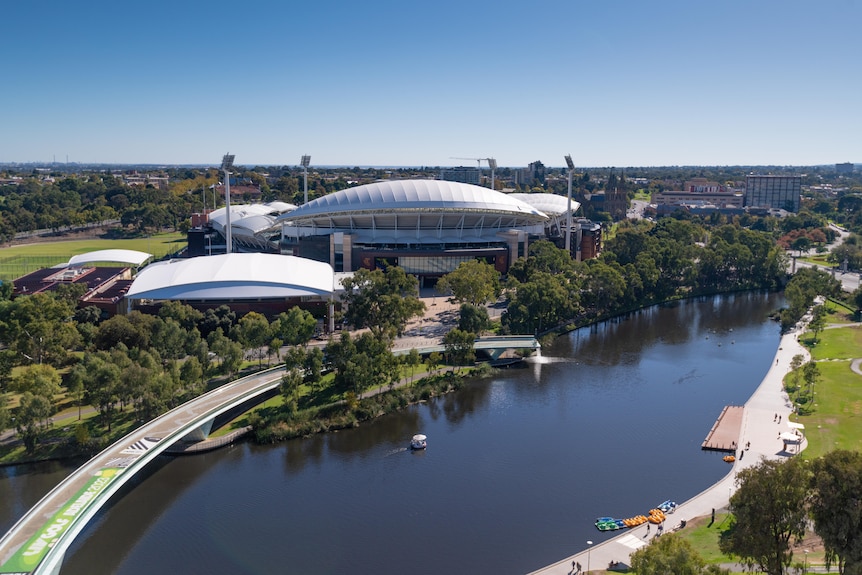 Adelaide Oval with the River Torrens and the pedestrian bridge with green signage on it
