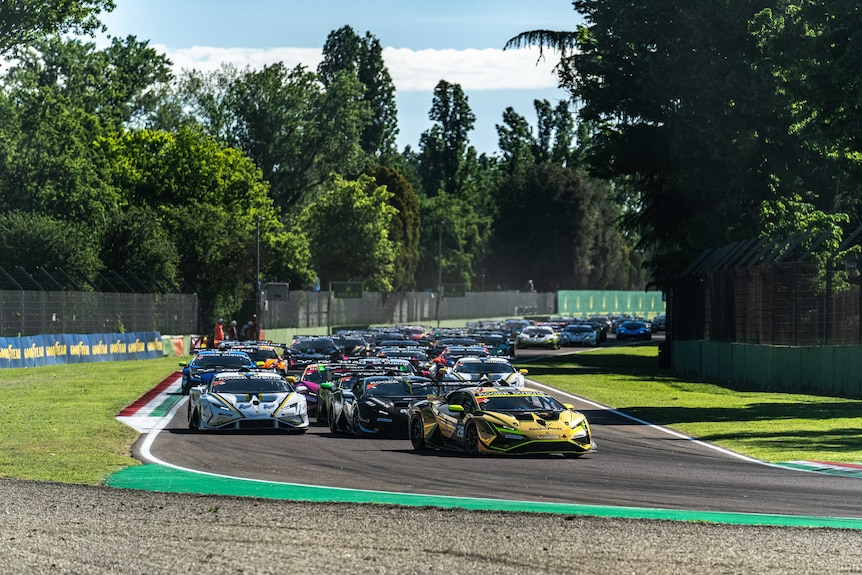Lamborghini cars take the first turn of the Imola race track. 