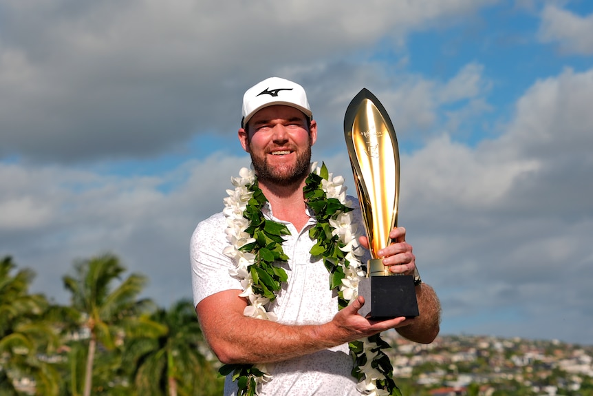 Grayson Murray holds a trophy