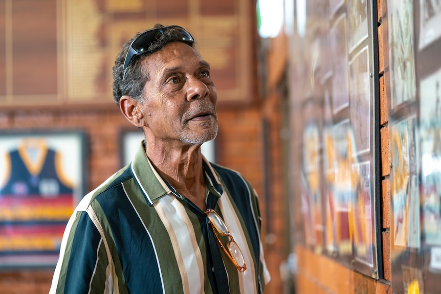Dennis Dunn looks at old photographs in the St Mary's club rooms.