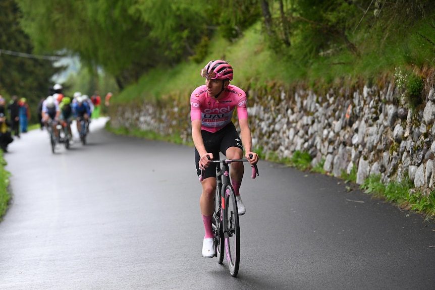 Tadej Pogacar rides away from other riders