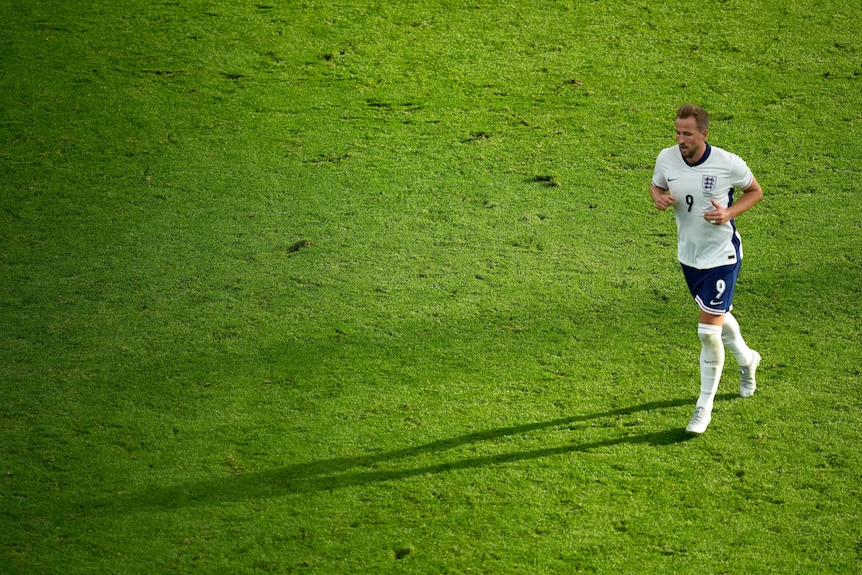 England striker Harry Kane jogs on the pitch during a game against Denmark at the European Championships.
