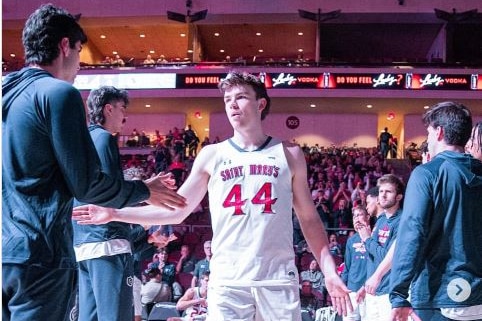 Man with number 44 basketball uniforms taps hands with team mates