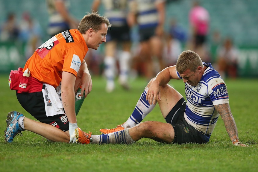 A man is treated for an injury on a rugby league field 