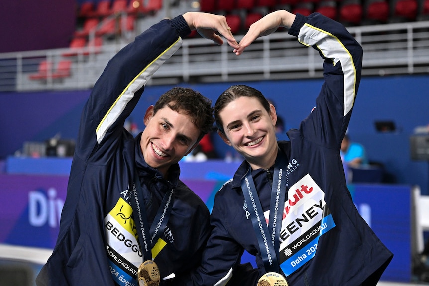 Maddison Keeney and Domonic Bedggood pose holding their hands above their head