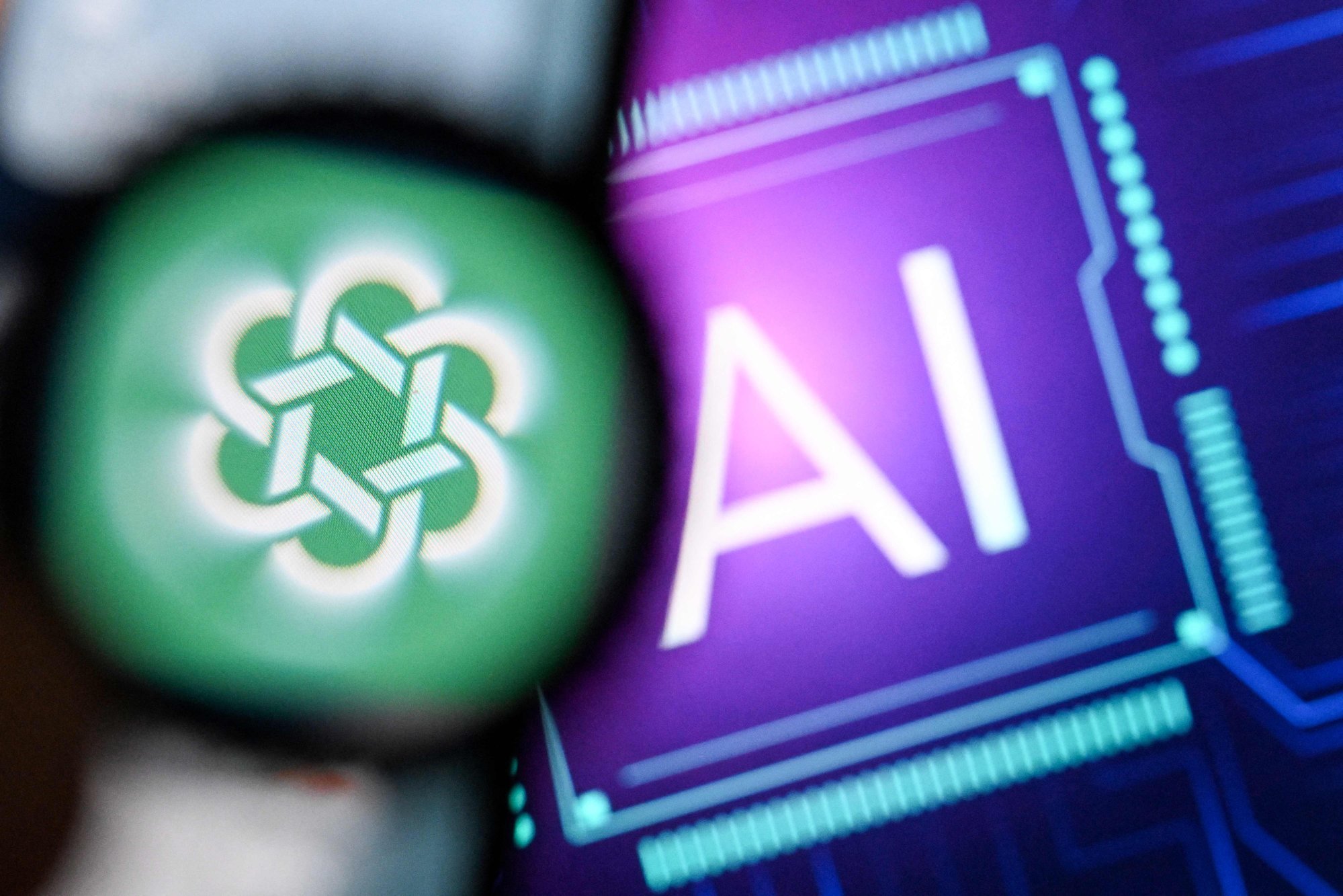 A photo taken on February 26, 2024 shows the OpenAI logo on a smartphone screen (left) and the letters AI on a laptop screen. Photo: AFP