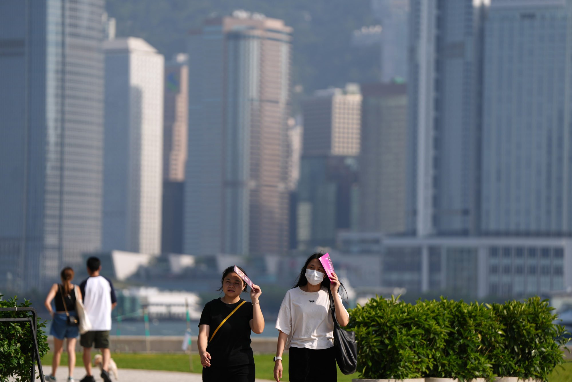 Walkers protect themselves from the heat in the West Kowloon Cultural District. Photo: Sam Tsang