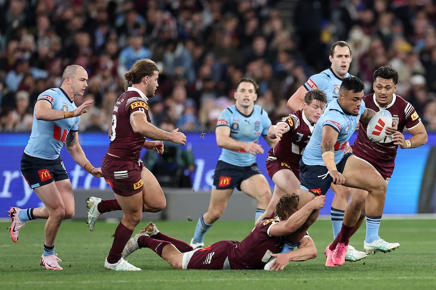 A man runs the ball during a rugby league match