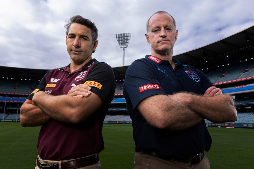 Two rugby league coaches pose with a trophy
