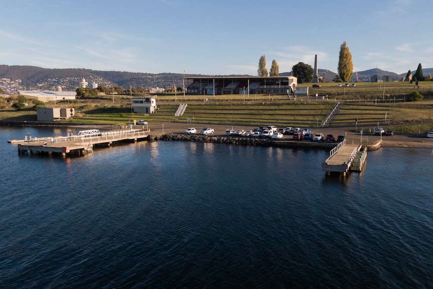 An aerial photo of a regatta stand and two wharfs over water.