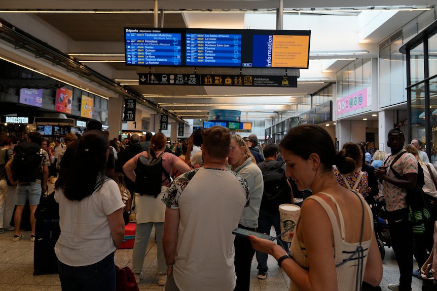 Passengers check train on an electronic board 