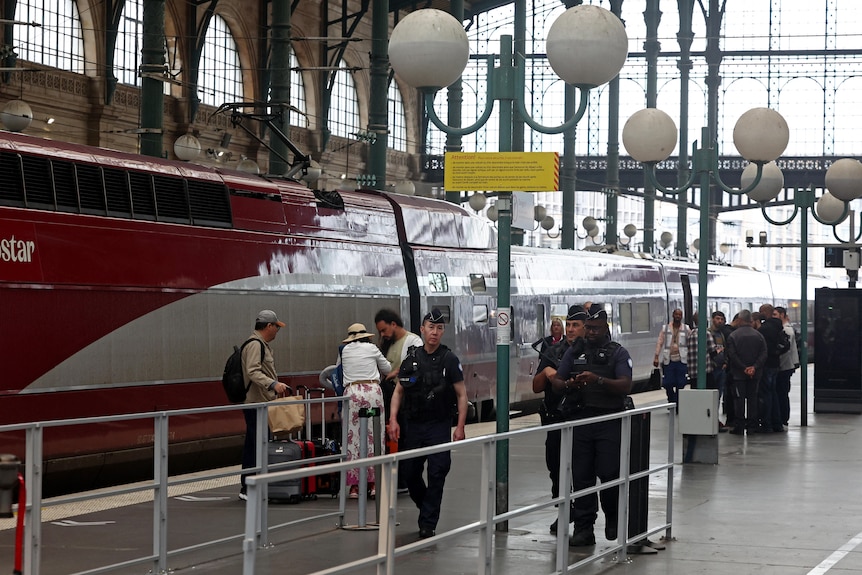 Police walk through a rail station 