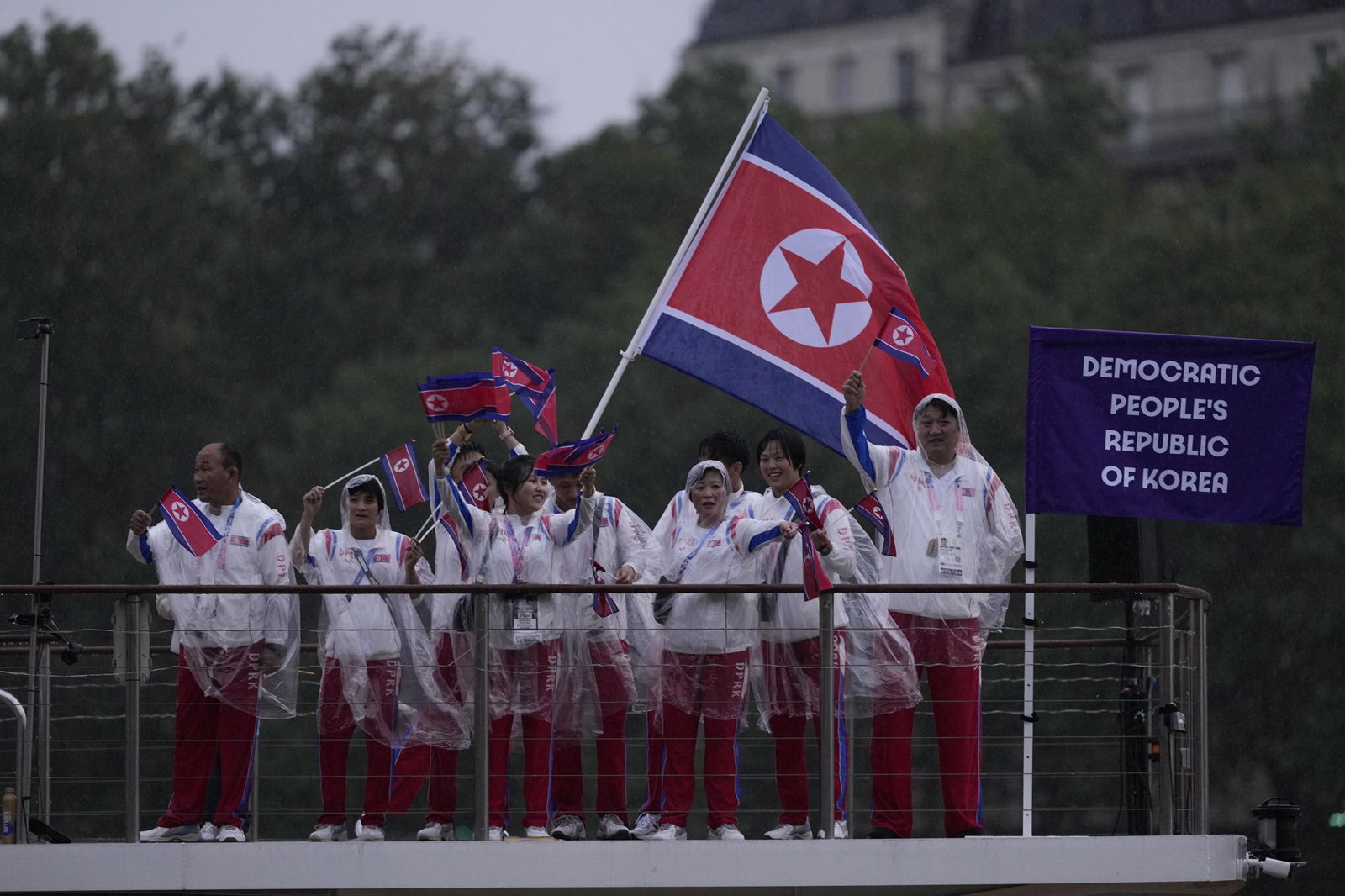 Athletes representing North Korea flying a flag aboard a boat in the opening ceremony at the Olympic Games in Paris.