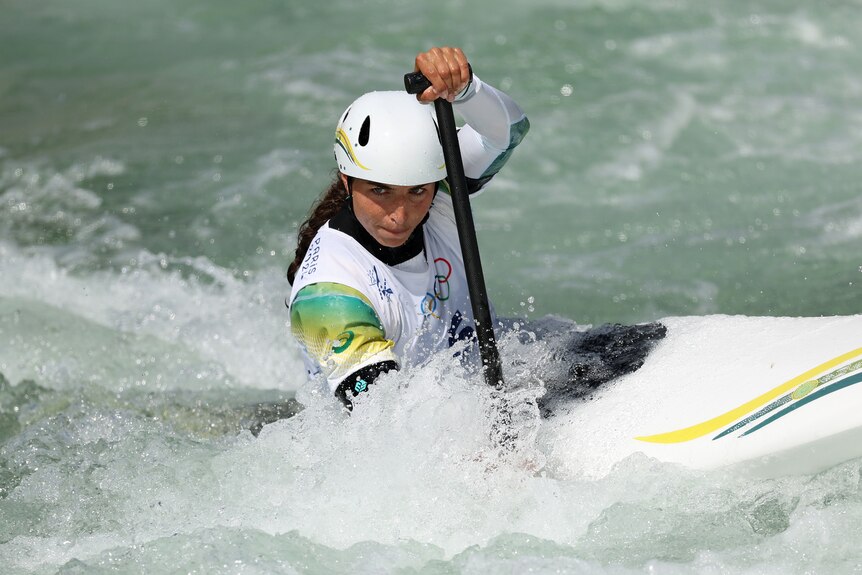 Australian canoeist Jess Fox uses her paddle to manoeuvre her kayak in white water as she looks down the course.