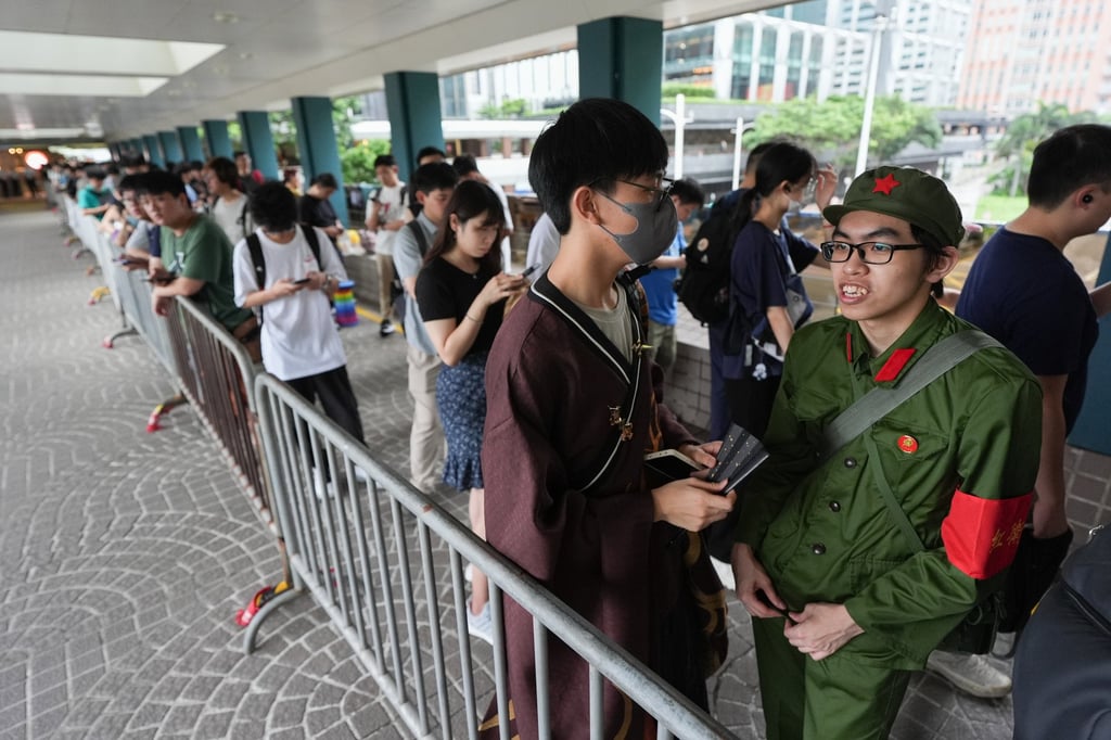 A cosplayer dressed up as a Red Guard queues alongside exhibition-goers outside the anime expo on Saturday. Photo: Eugene Lee