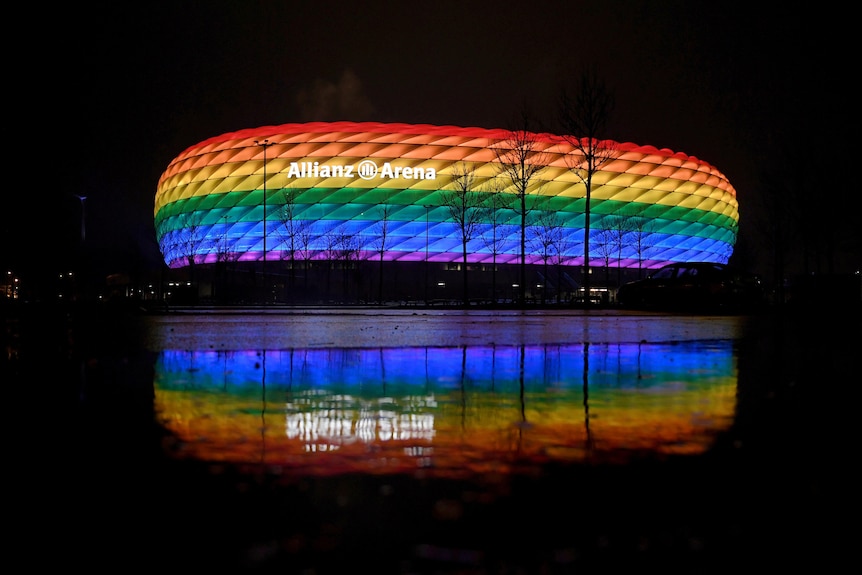Photo of a stadium lit up with rainbow colours
