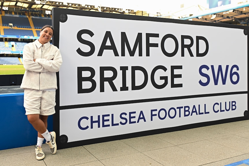 Sam Kerr poses after re-signing with Chelsea.