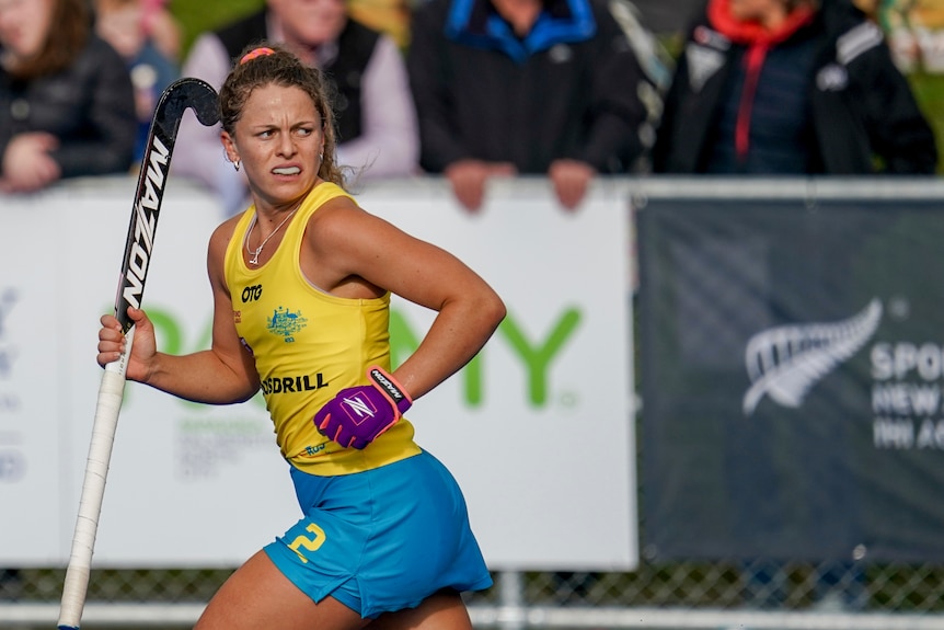 Rosie Malone runs carrying her stick during a game