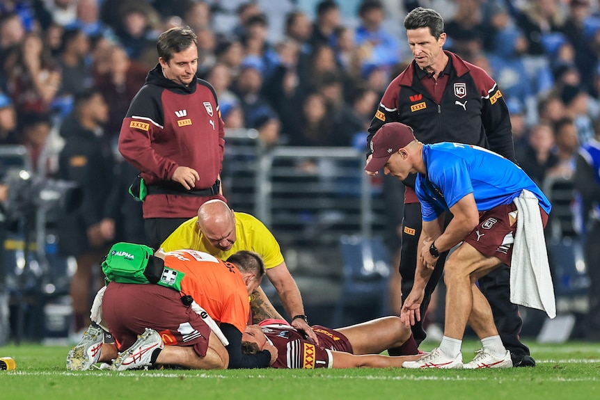 Reece Walsh of the Maroons is attended to after being tackled by Joseph-Aukuso Sua'ali'i of the Blues