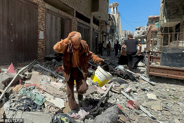 A Palestinian man walks near an apartment hit in an Israeli strike, amid Israel-Hamas conflict, in Gaza City, August 26, 2024