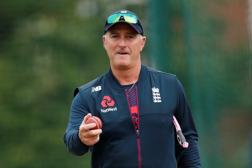 Man with a cricket ball prepares to throw it. 