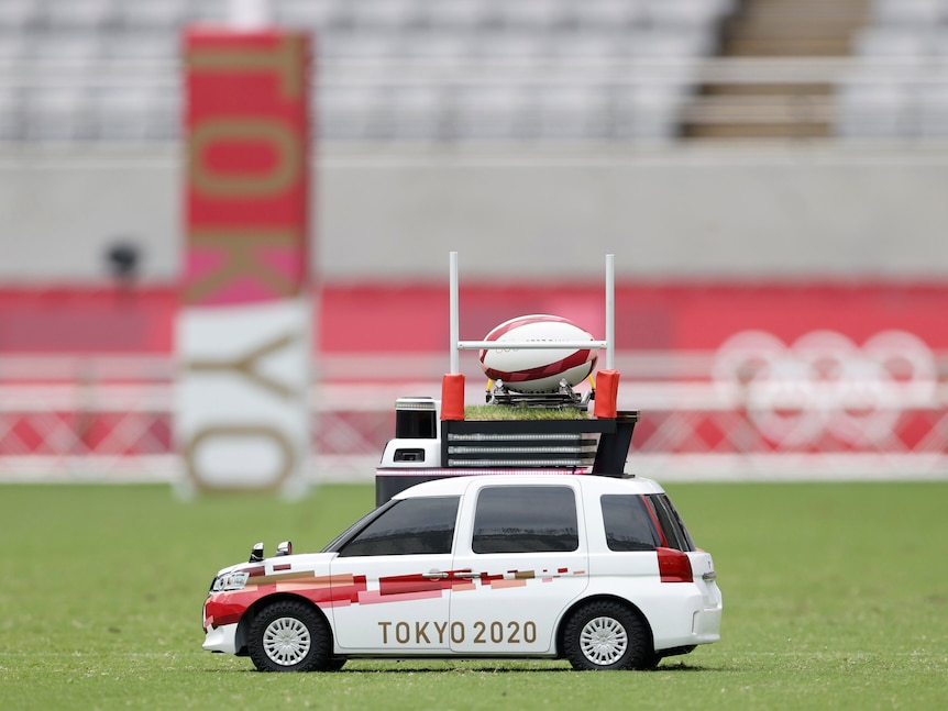 An RC modelled after an SUV carries a rugby ball 