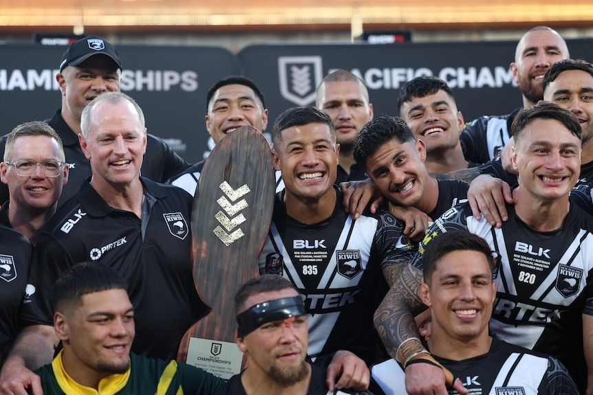 Kiwis players and coaches celebrate defeating the Kangaroos in the Pacific Championships final.