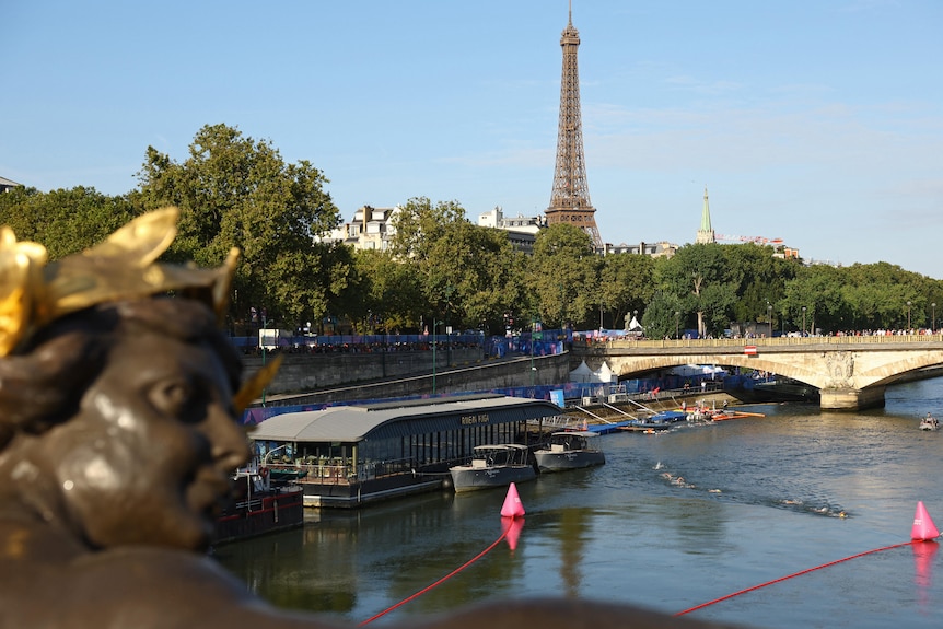 The Eiffel Tower as people swim in the Seine