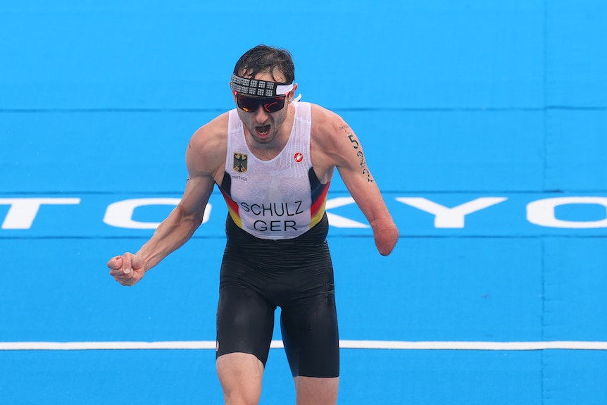 German paratriathlete Martin Schulz, an arm amputee, celebrates winning gold after he crosses the line.