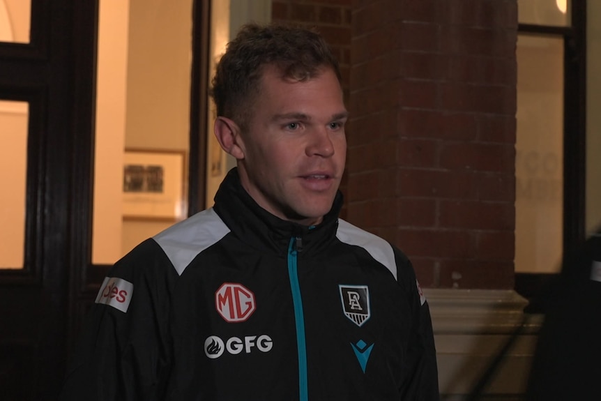 Dan Houston in Port jacket outside a building at night
