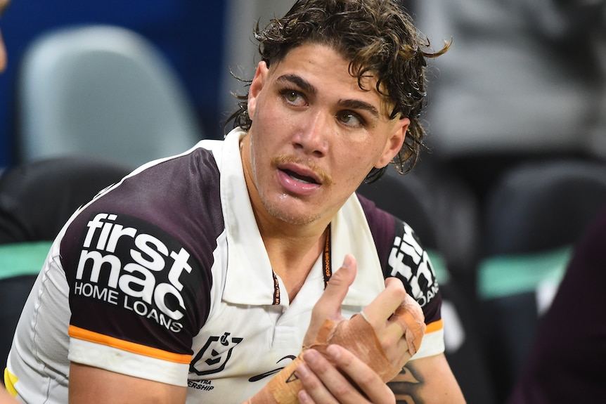 Reece Walsh of the Brisbane Broncos holding his right hand which is fractured
