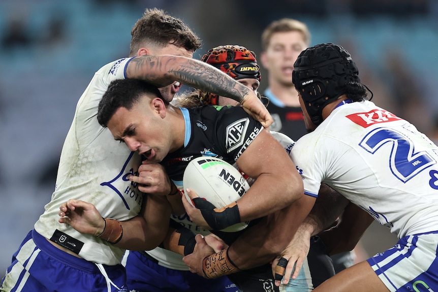 A man runs the ball during a rugby league match