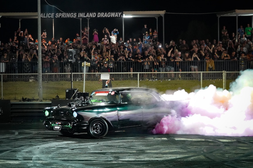 Thick smoke rises from a burnout vehicle.
