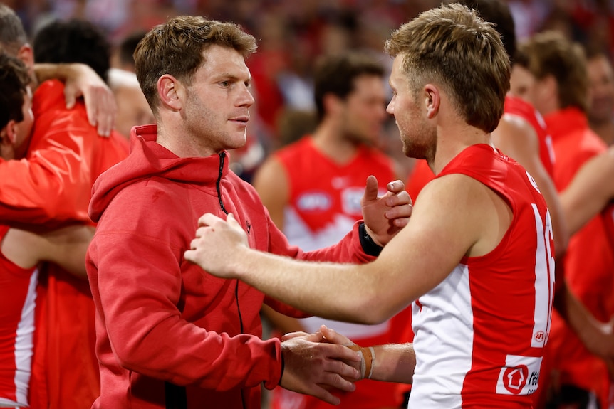Taylor Adams shakes hands with a Sydney Swans teammate.
