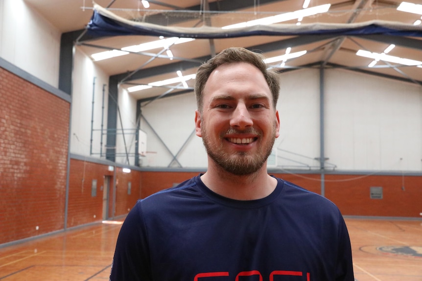 man in blue shirt smiles at camera