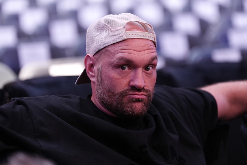 Tyson Fury sits and looks to the side