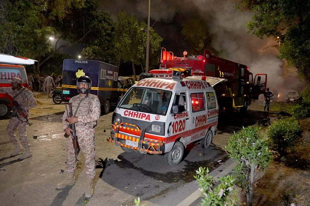 Paramilitary soldiers stand guard close to the site of an explosion outside Karachi airport, Pakistan on Sunday. Photo: AP