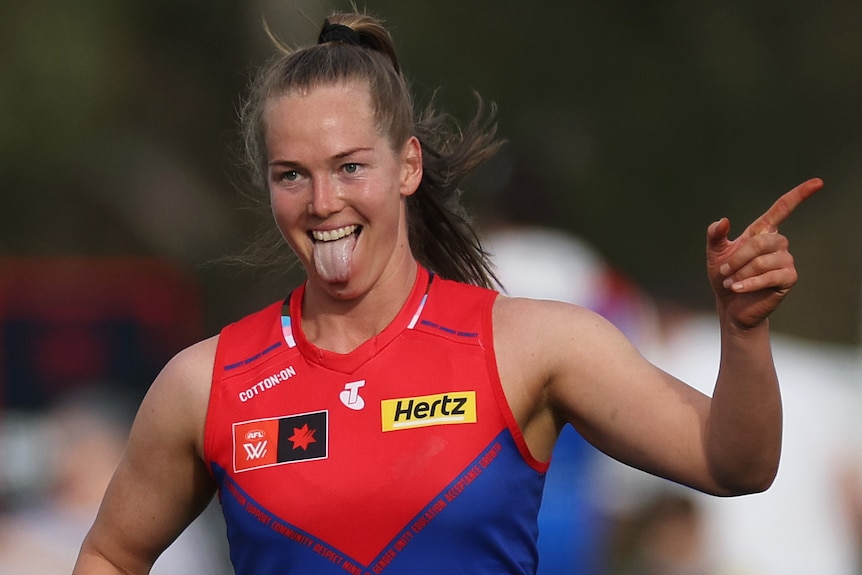 Eden Zanker points a finger on her left hand as she celebrates an AFLW goal for the Demons.