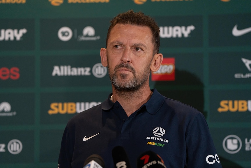 Socceroos Coach Tony Popovic press conference speaking into TV microphones.