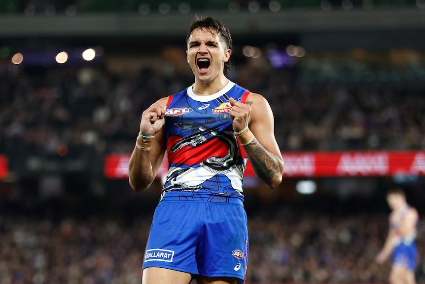 A man grabs his jumper and gestures to the crowd.