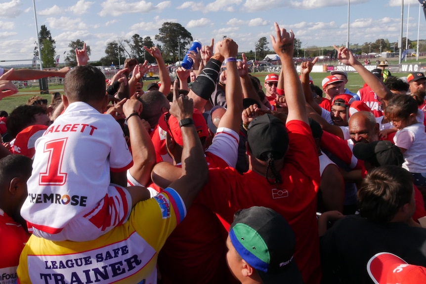 a rugby league team celebrating winning a grand final