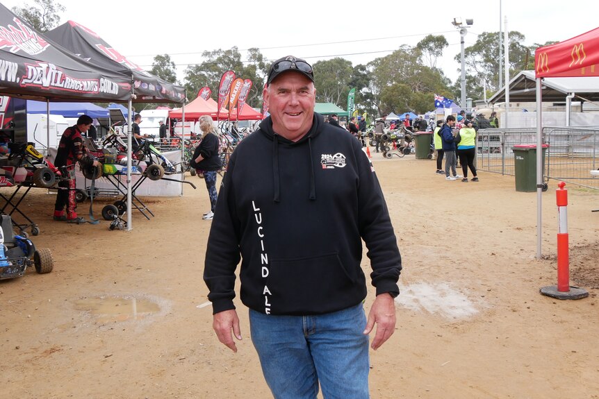 A man wearing a black jumper with the word LUCINDALE on it among marquees