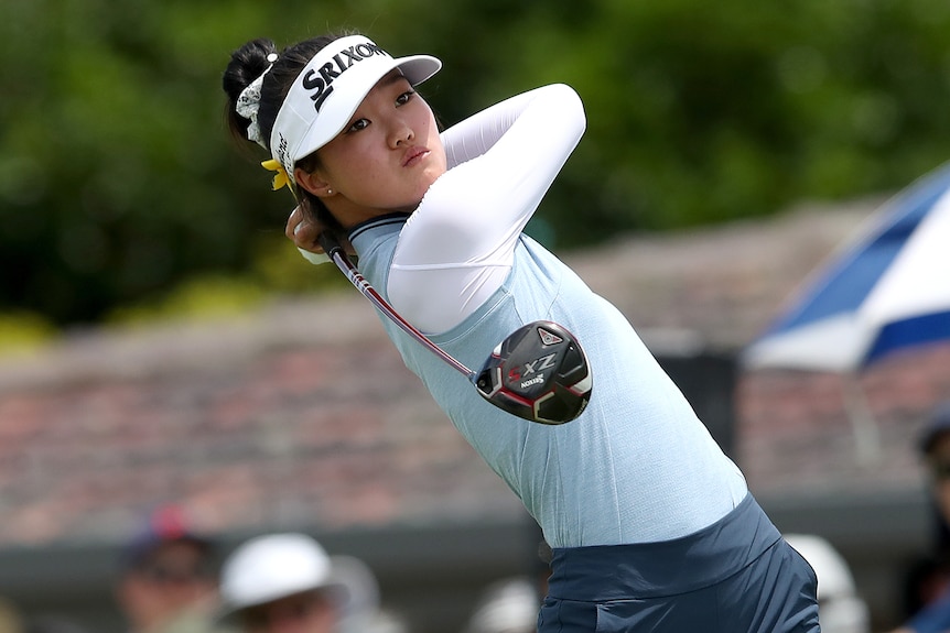 An Australian female golfer hits a shot with a club during a tournament in Brisbane.